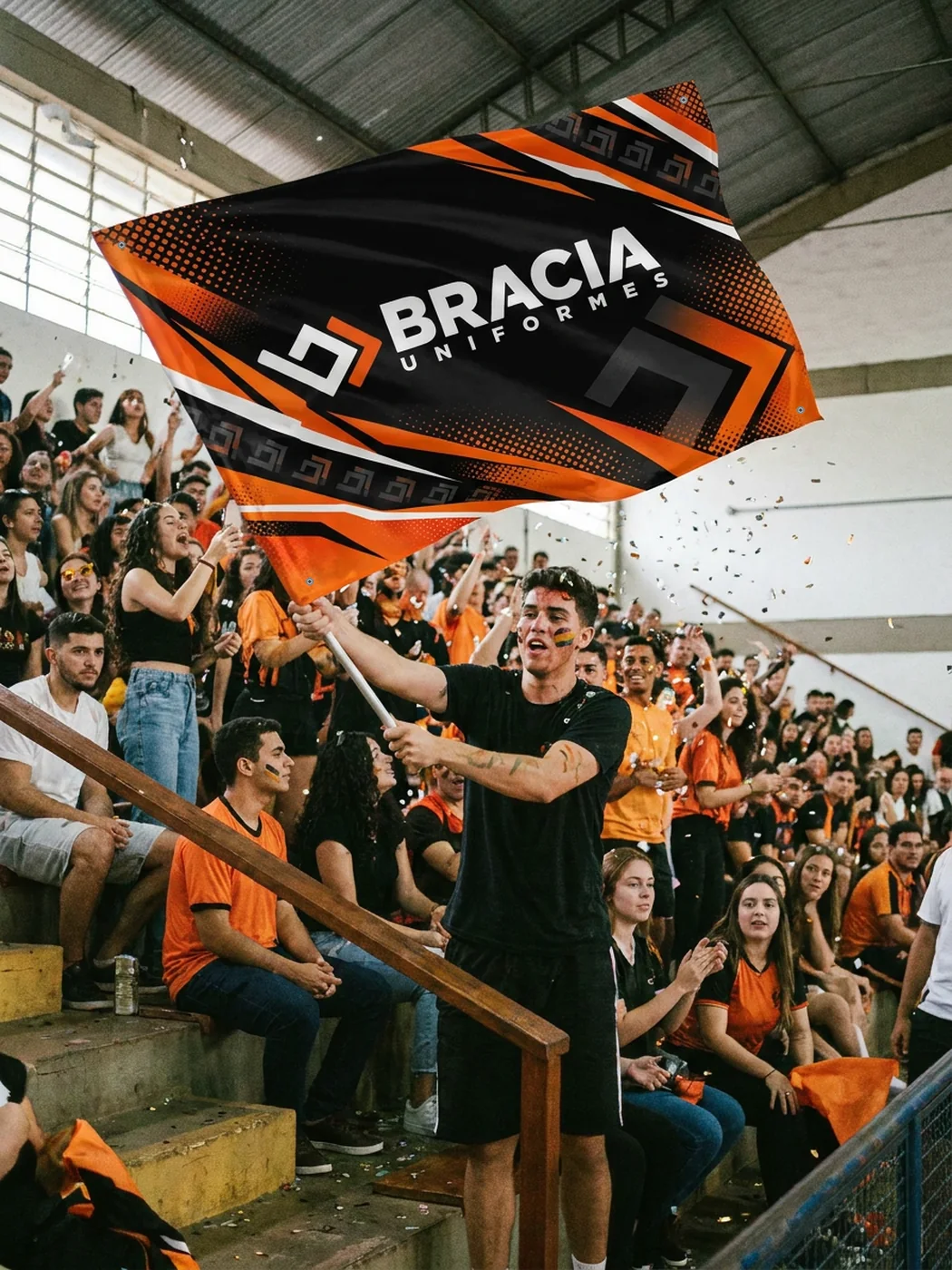 Torcedor agitando a bandeira preta e laranja da Bracia na arquibancada de um ginásio