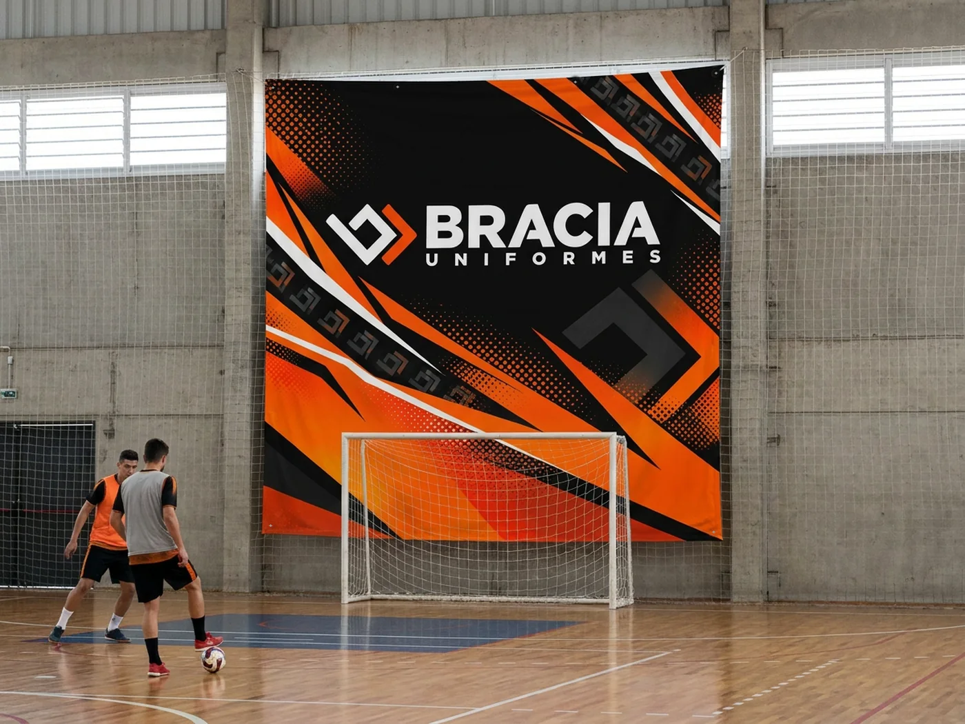 Bandeirão da Bracia pendurado na parede atrás do gol de um ginásio de esportes, com jogadores na quadra